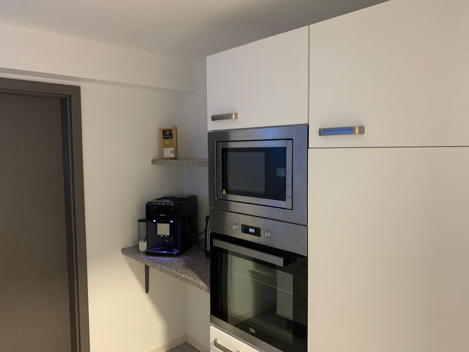 Küche mit Backofen, Mikrowelle und Kaffeemaschine